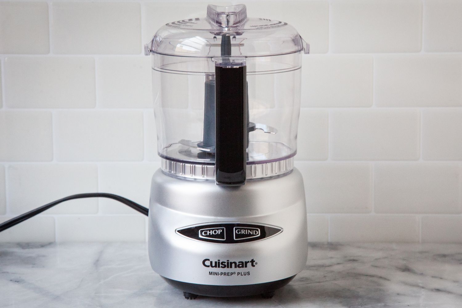 A small Cuisinart food processor on a marble countertop.