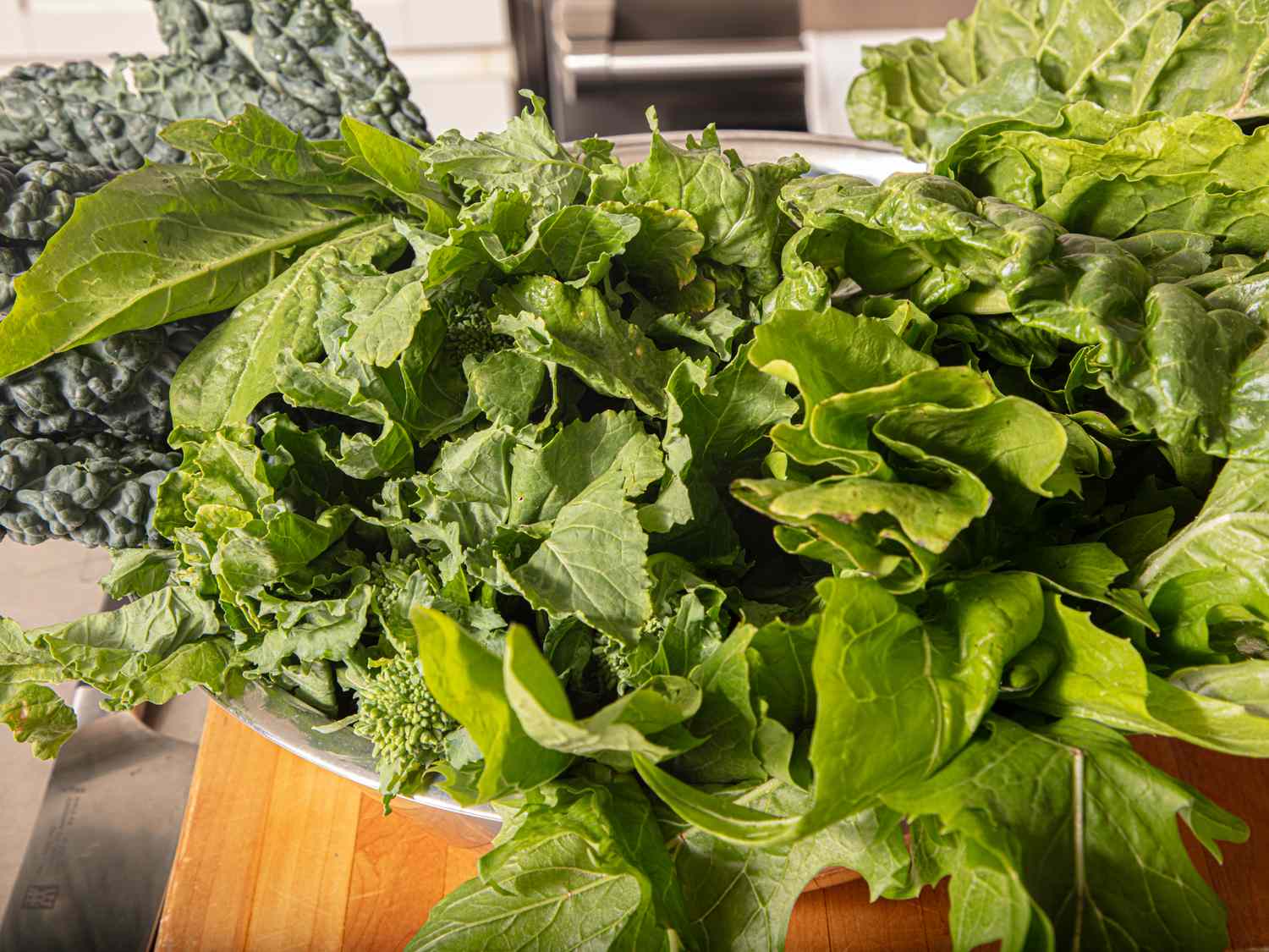 A mix of leafy greens on a wooden surface