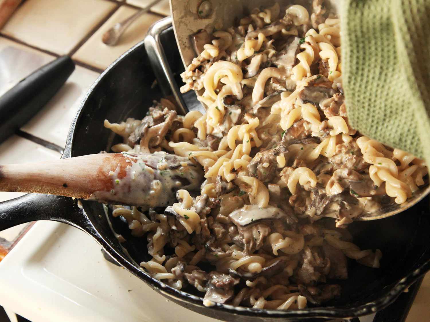 Adding pasta and sauce back into the skillet.