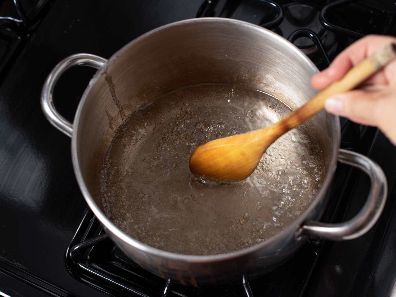 Sugar and water boiling on stovetop.