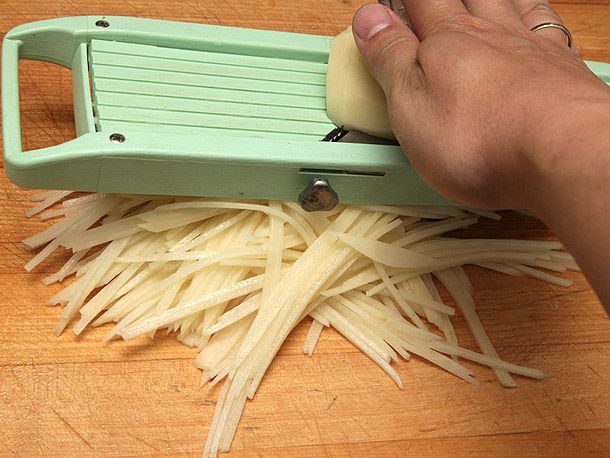 Author juliennes a potato with a benriner brand mandoline.