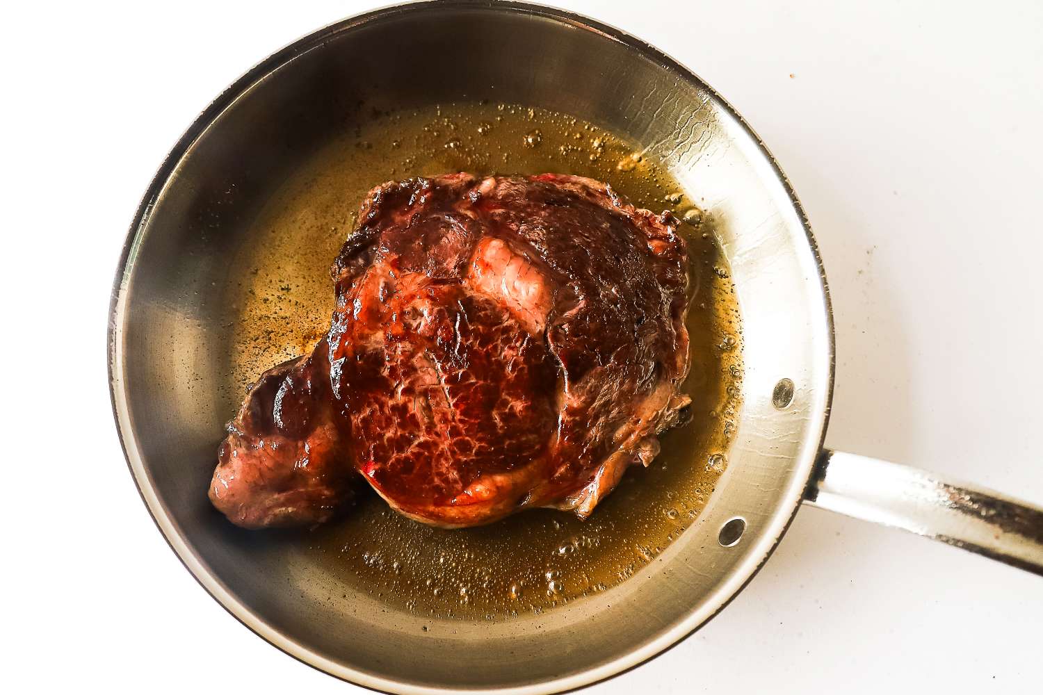 A cooked steak in a frying pan