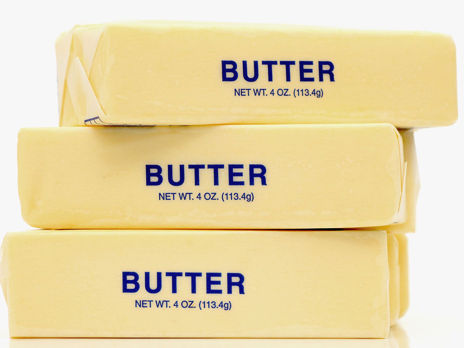A stack of three sticks of butter in their wrappers.
