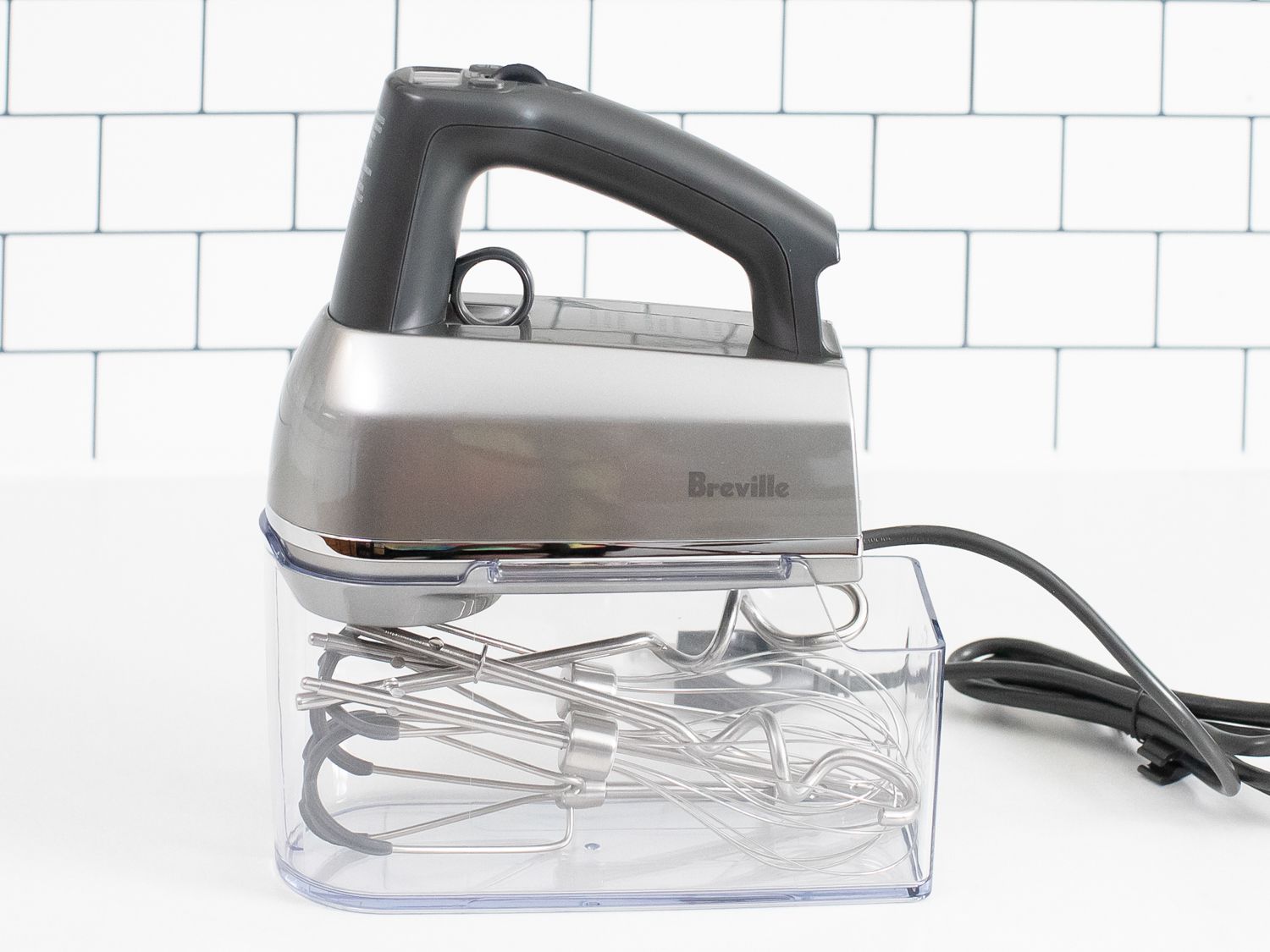 The Breville Hand Mixer on a white kitchen countertop