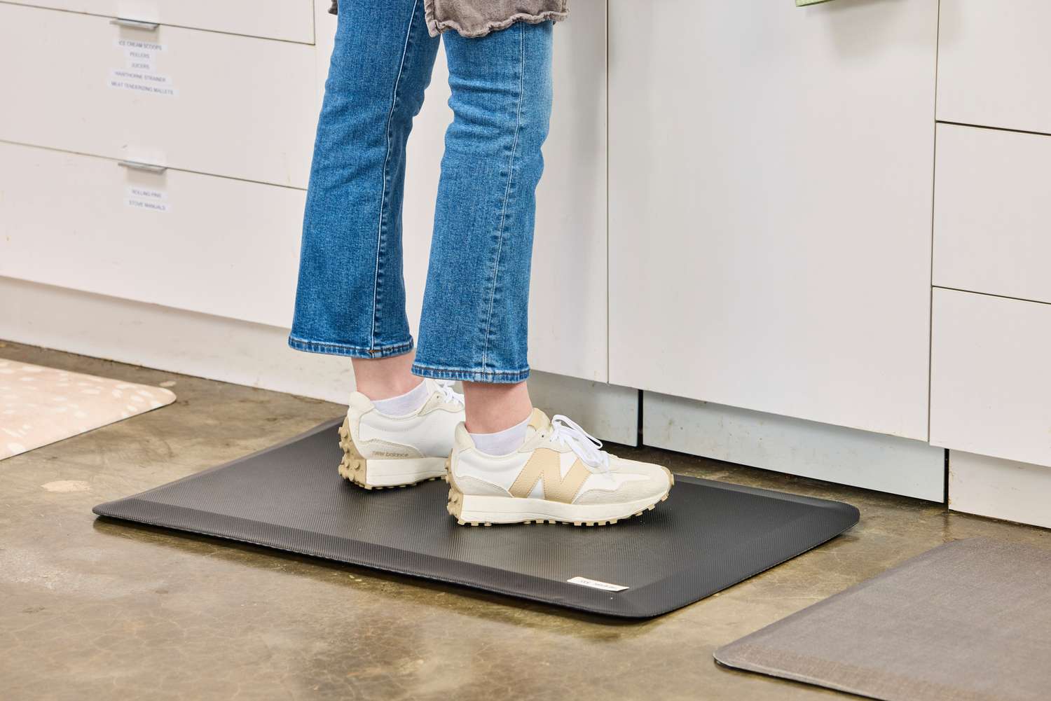 A person stands on the Sky Solutions Sky Mat 0.75-Inch Comfort Anti-Fatigue Mat