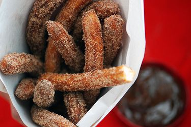 Closeup of churros in a paper cone.
