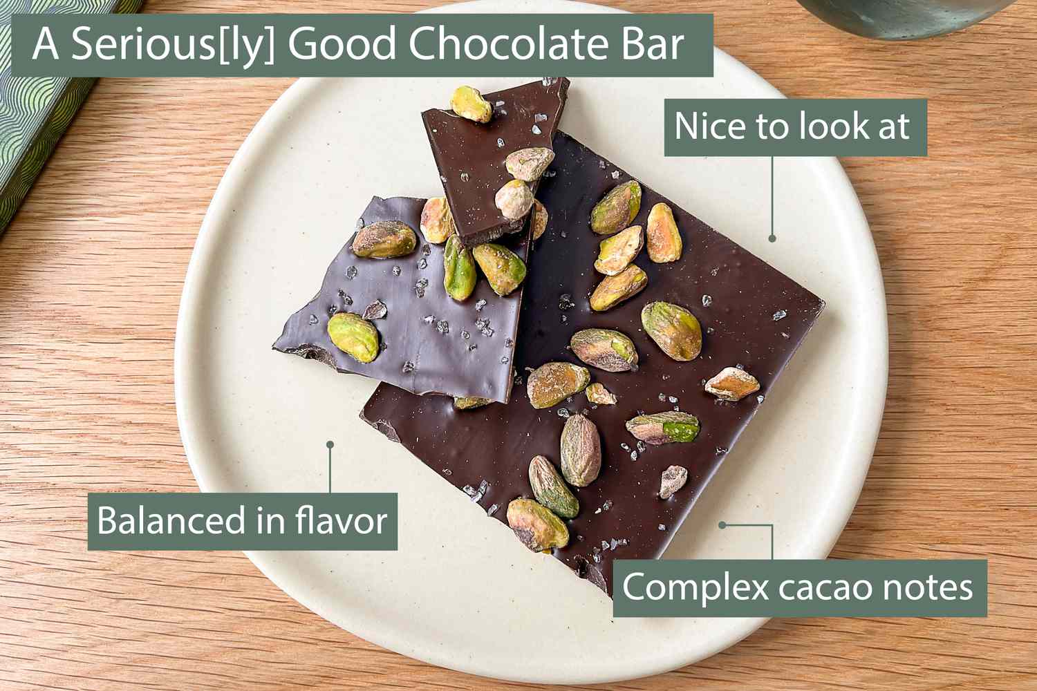 A dark chocolate pistachio chocolate bar on a small plate