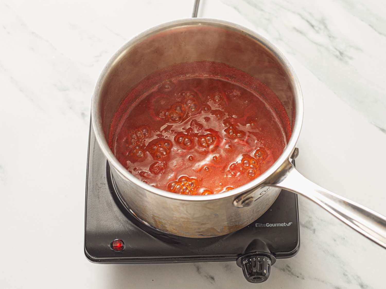 Sauce simmering in a pot on a stovetop.