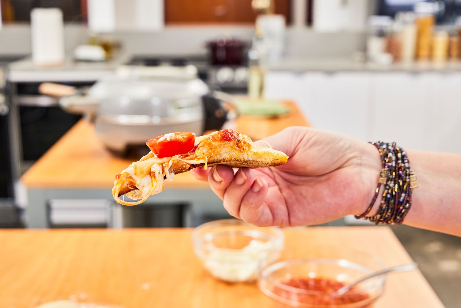 A person holding a slice of pizza.