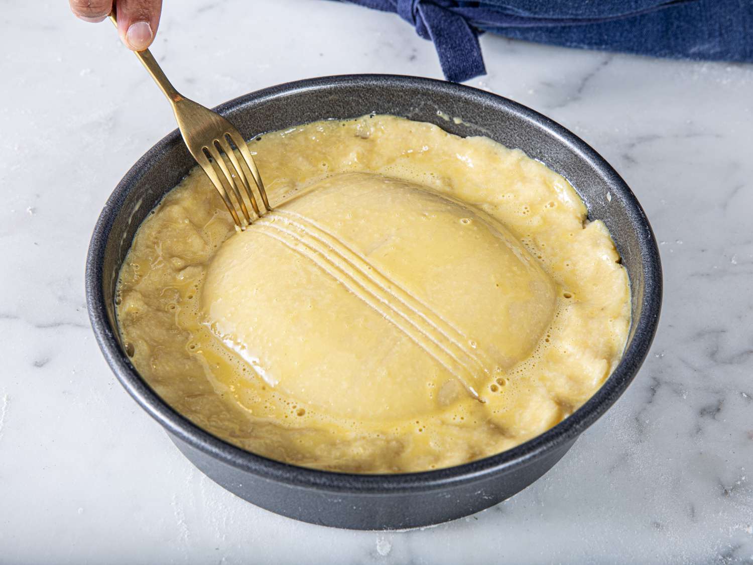 Overhead view of pastry being crosshatched with a fork