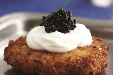 Closeup of a Latke topped with Caviar and Sour Cream