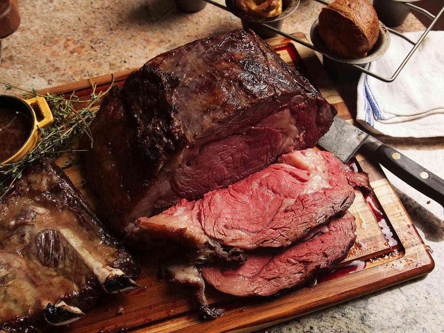 A sliced prime rib on a wooden carving board.