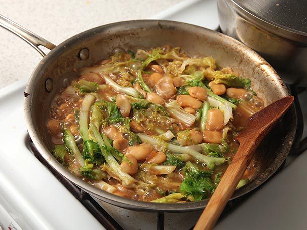 A skillet full of braised butter beans and escarole.