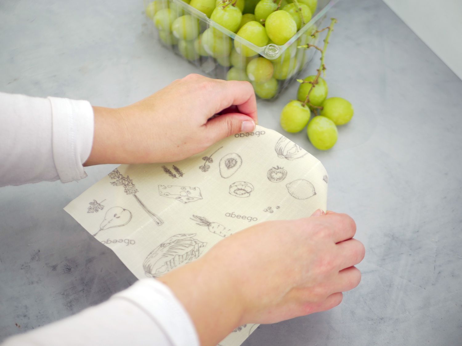a person covering a bowl with beeswax wrap
