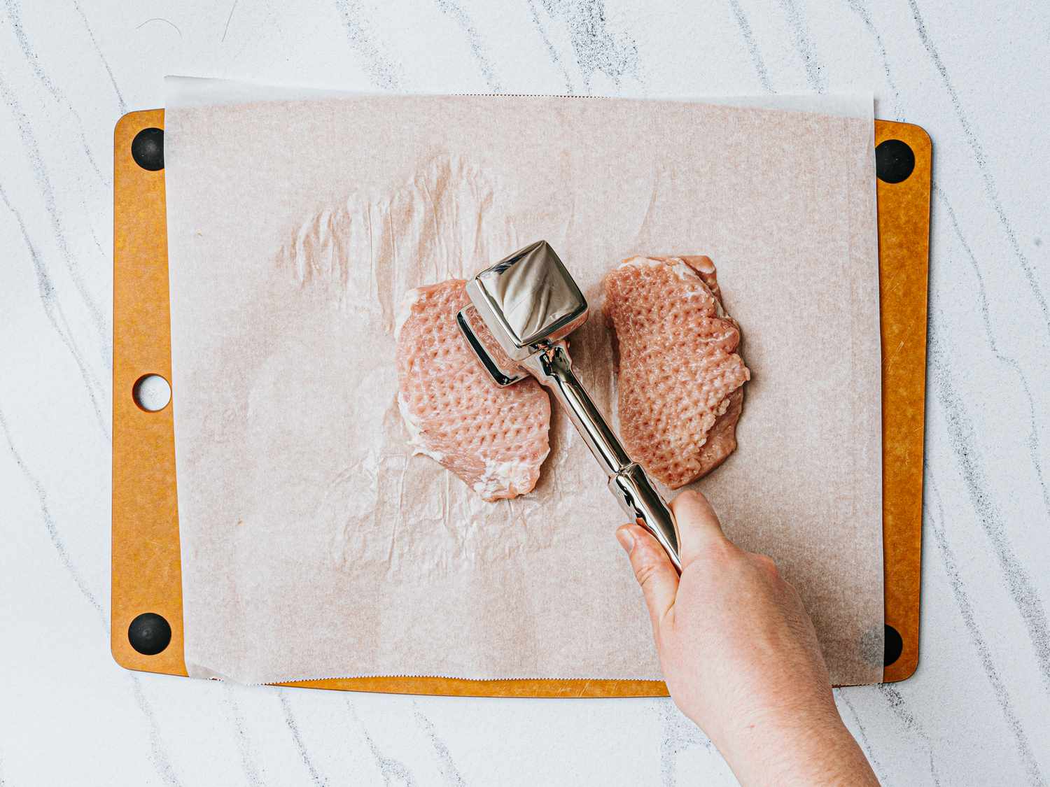 Overhead view of pounding porkchops