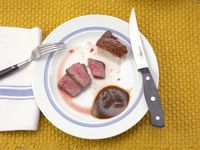a cuisinart steak knife on a plate with sliced meat