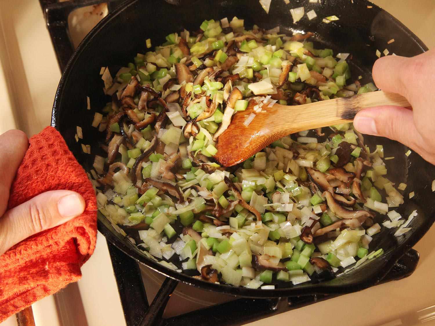 Sautéing shiitakes and aromatics in a cast iron skillet.