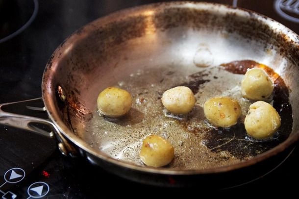 Matzo balls shallow-frying in a pan on the stove