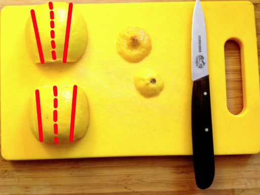 Lemons with their cut sides resting on a cutting board with superimposed lines showing the locations to cut the lemons to make wedges.