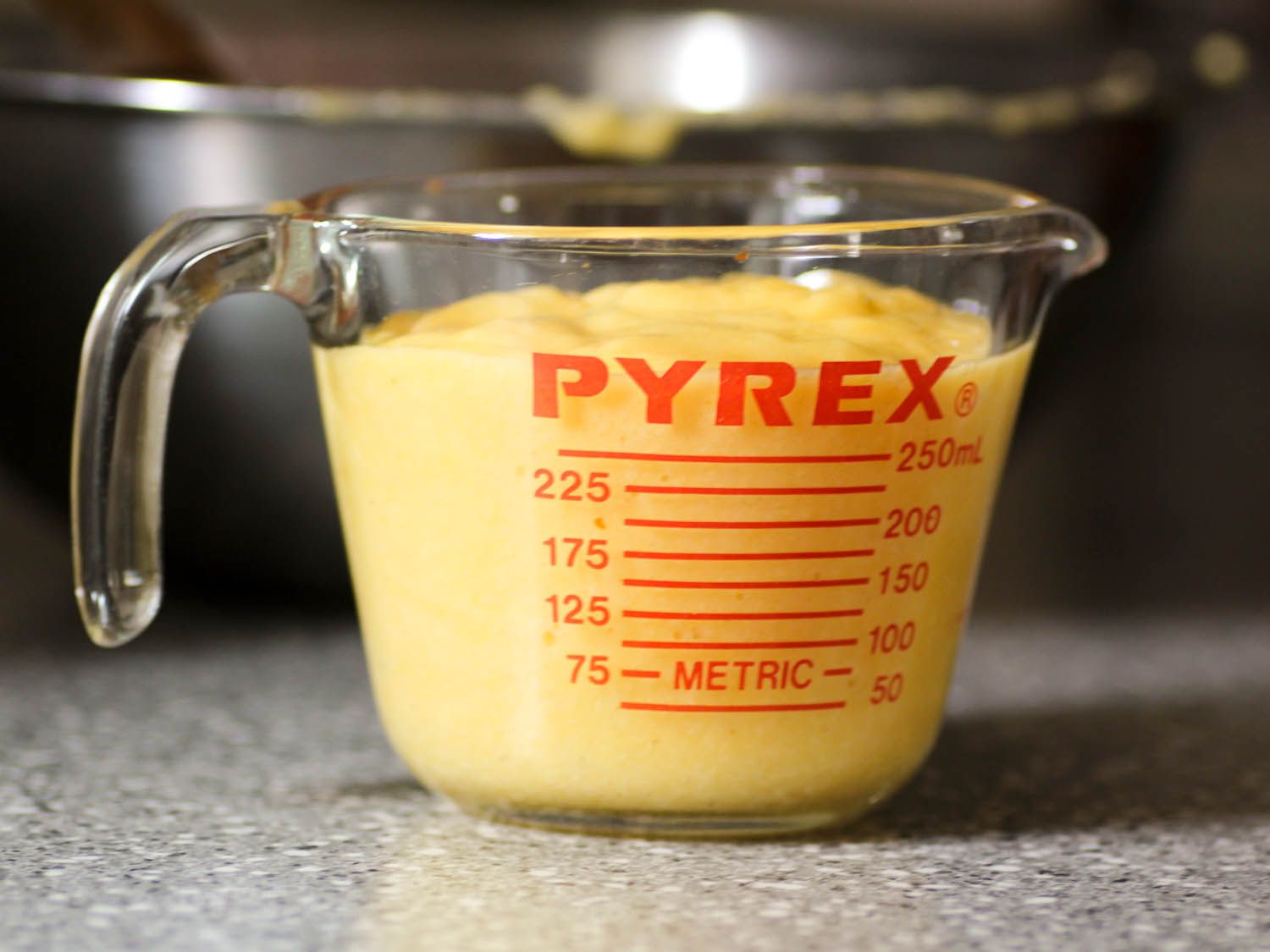 Pawpaws pulp resting in a Pyrex glass measuring cup