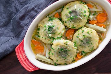 Overhead view of Artichokes à la Barigoule, served in a enalemed oval casserole dish.