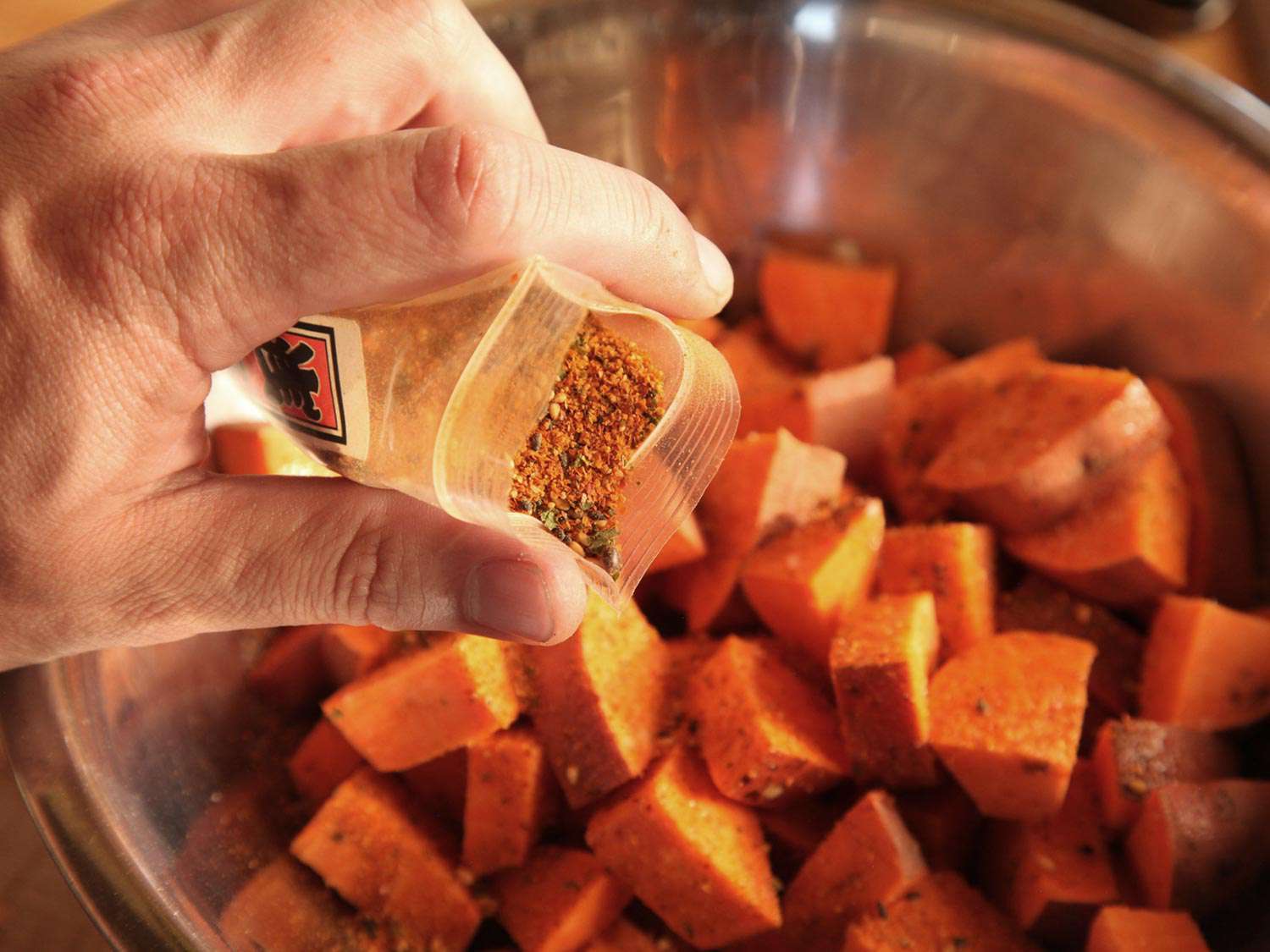Adding shichimi togarashi to sweet potatoes for vegan ramen.