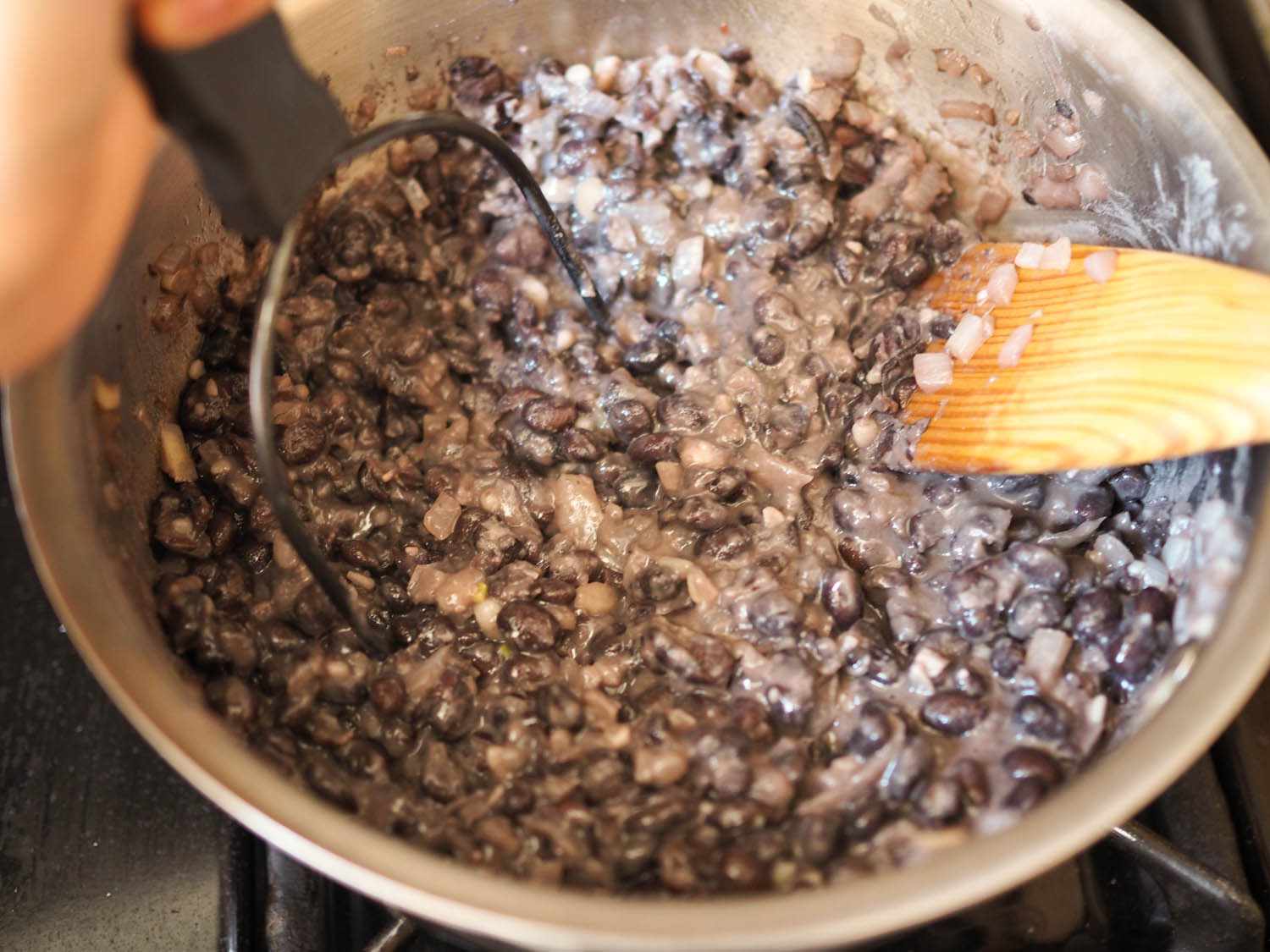 Author mashing the bean mixture in a skillet.