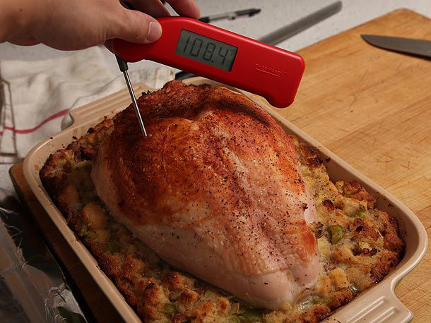 Testing the temperature of roast turkey breast.