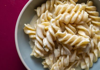 Closeup of pasta ai quattro formaggi, served in an eggshell-colored bowl.