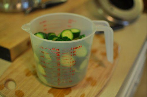 Sliced cucumber in a measuring cup, ready to pickle.