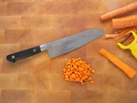 morihei hisamoto knife on a wooden cutting board with carrots