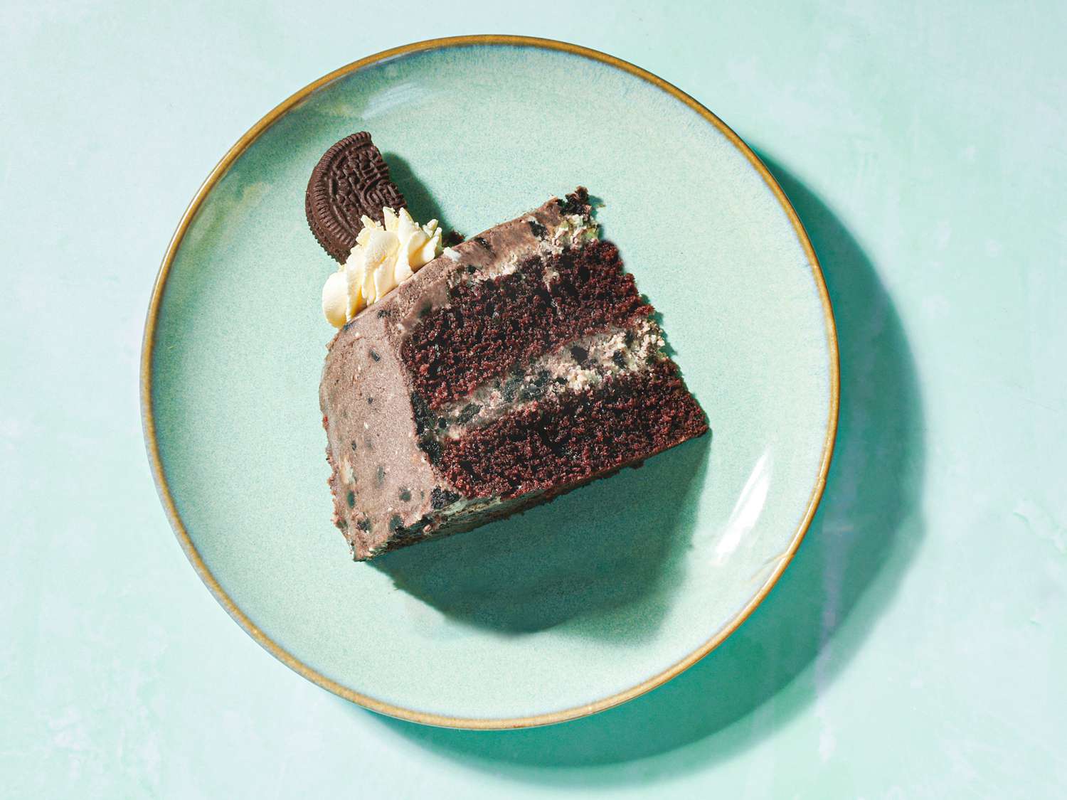Slice of oreo cake on a green plate.