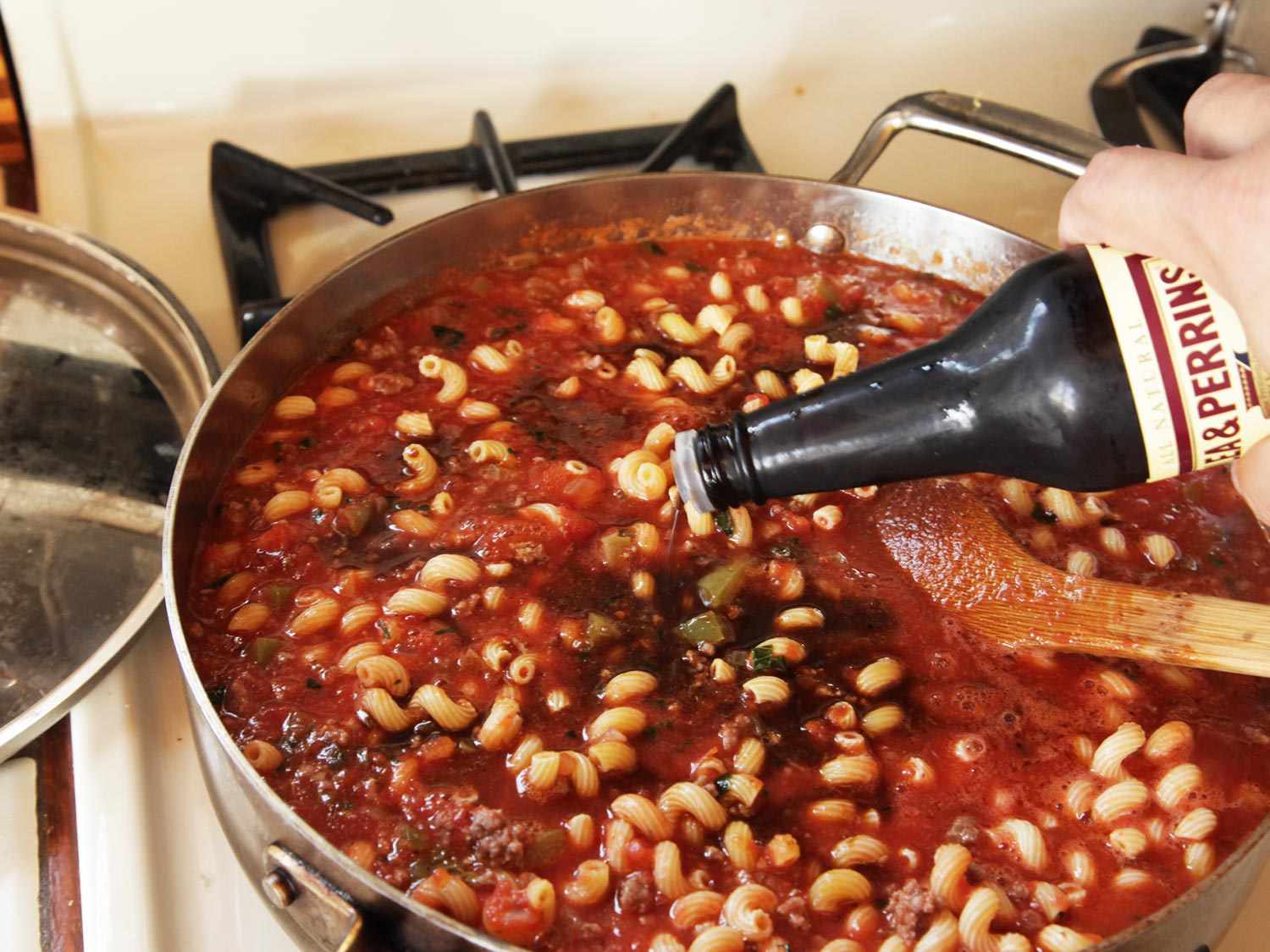 Author adding dashes of Worcestershire sauce to the pan directly from the bottle.