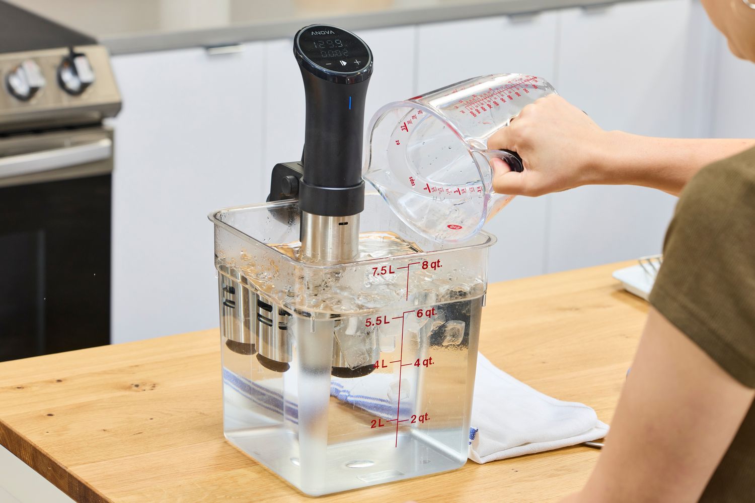 Person pouring water into a Anova Culinary Precision Cooker 3.0 on a countertop