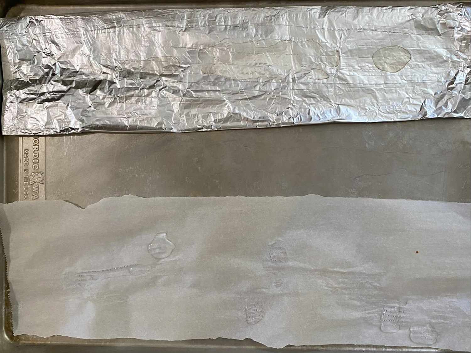 A baking tray lined with foil on one side and parchment paper on the other