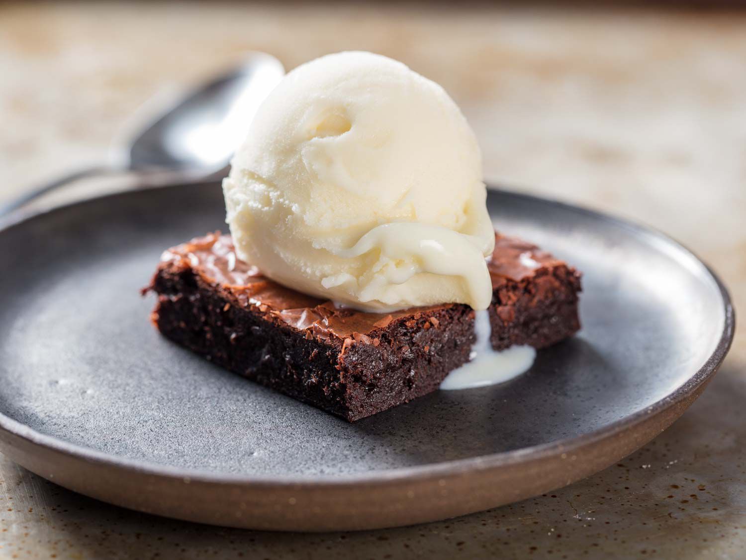 A scoop of vanilla ice milk, served on a brownie.