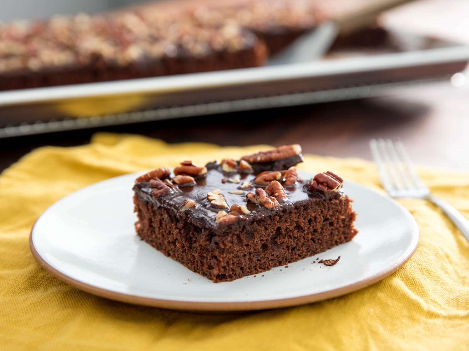 A square of pecan-topped Texas sheet cake on a white plate
