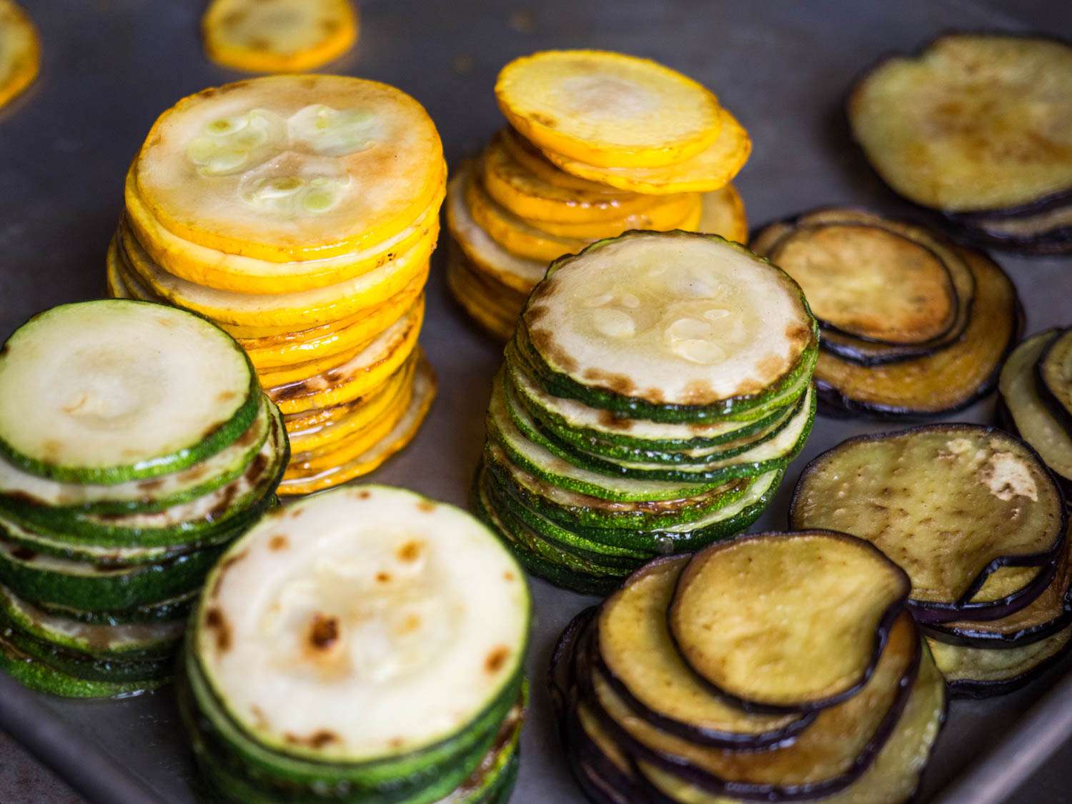 Stacks of seared slices of eggplant, zucchini, and yellow summer squash.