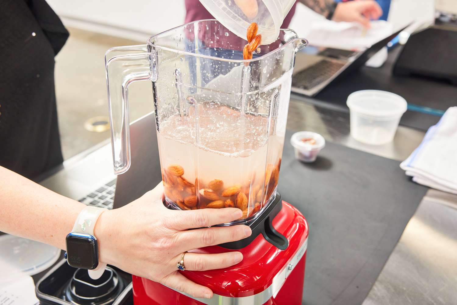 Almonds and milk are combined in the jar of the KitchenAid K150 blender.