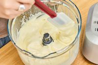 A person stirs puree made in the Breville BFP660SIL Sous Chef 12-Cup Food Processor