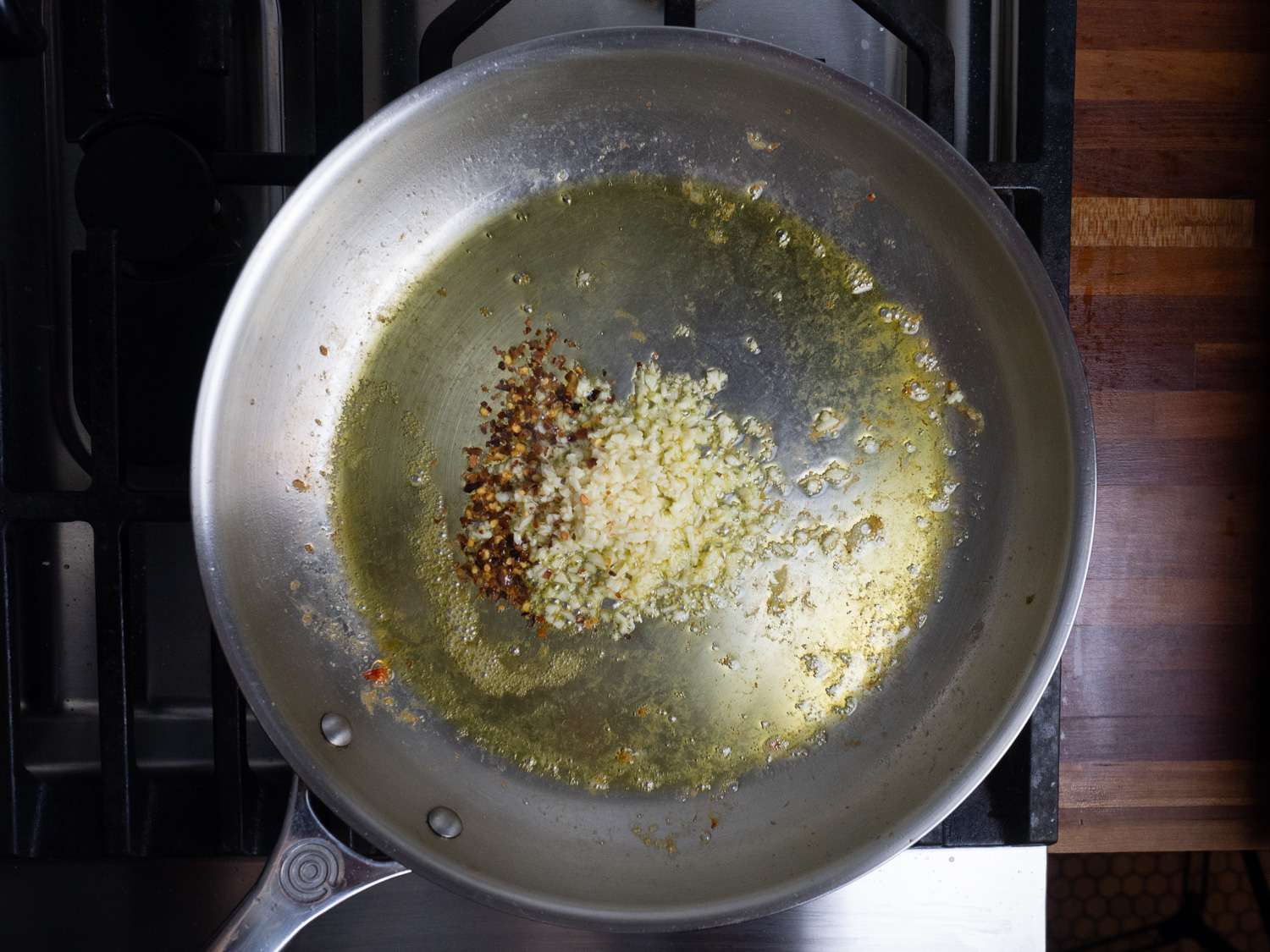 Garlic and pepper flakes with oil in a skillet.