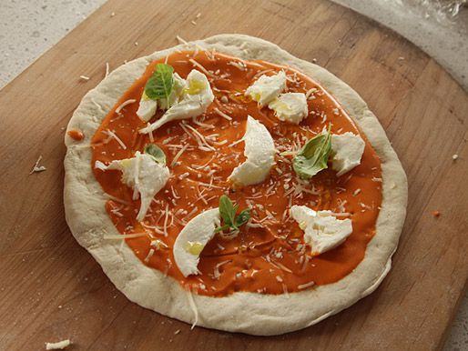 The vodka pizza is assembled on a peel, ready for the oven.