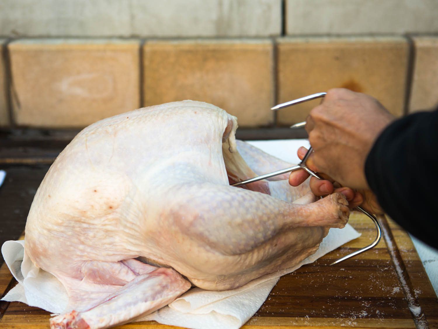 Inserting a turkey hanger deeper into a turkey.