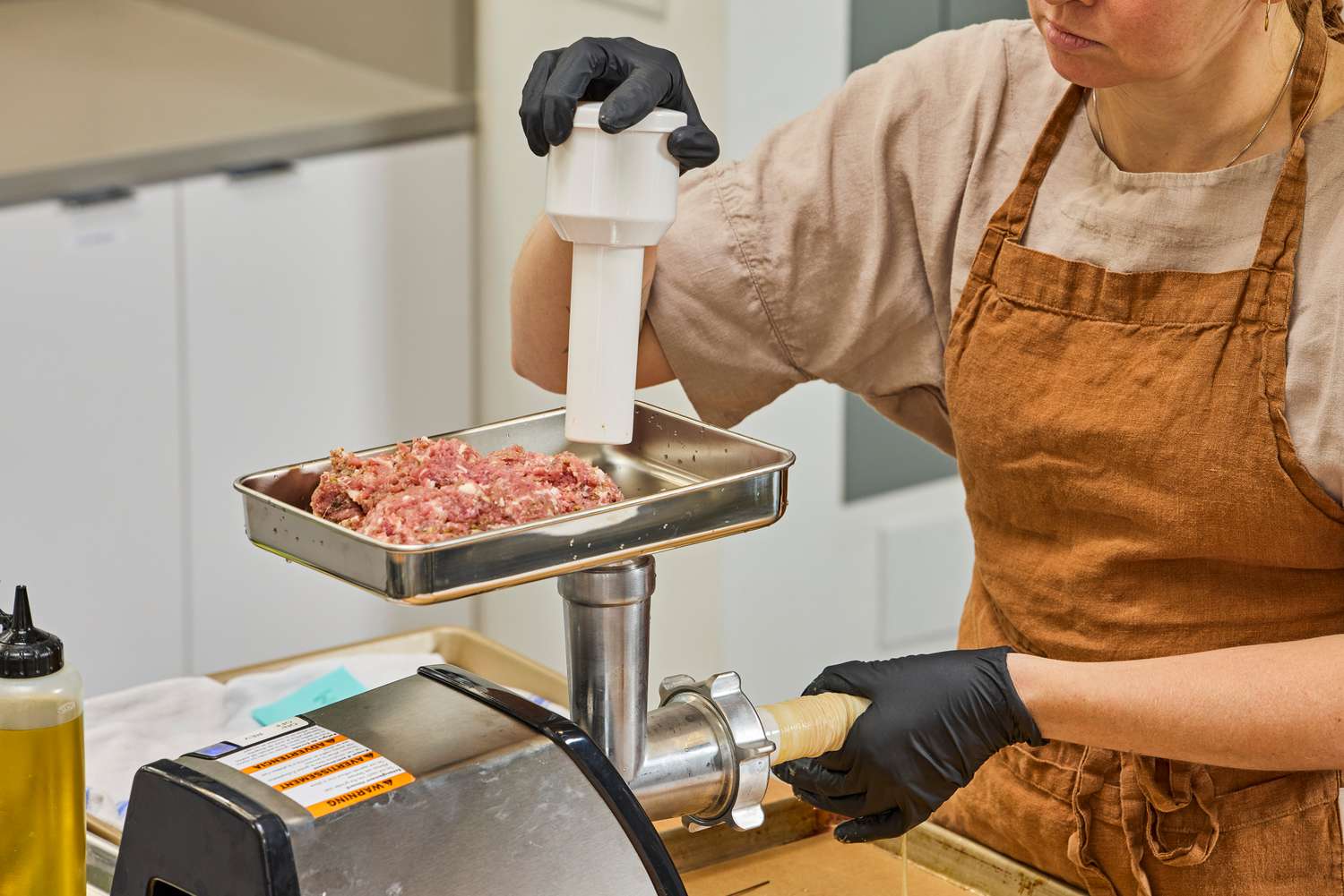 Person pushing meat in Weston #8 Electric Meat Grinder to stuff
