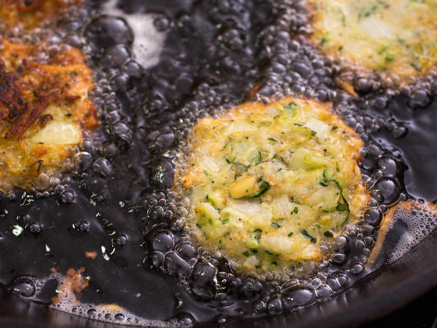 Zucchini latkes frying in oil