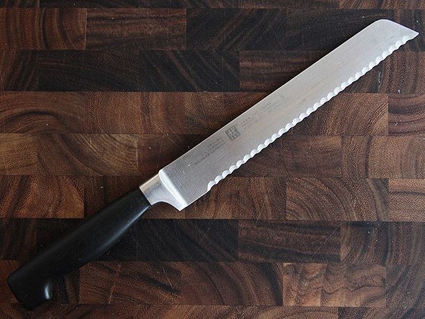 Zwilling J.A. Henckel's Four Star 8-Inch Bread Knife on wood cutting board