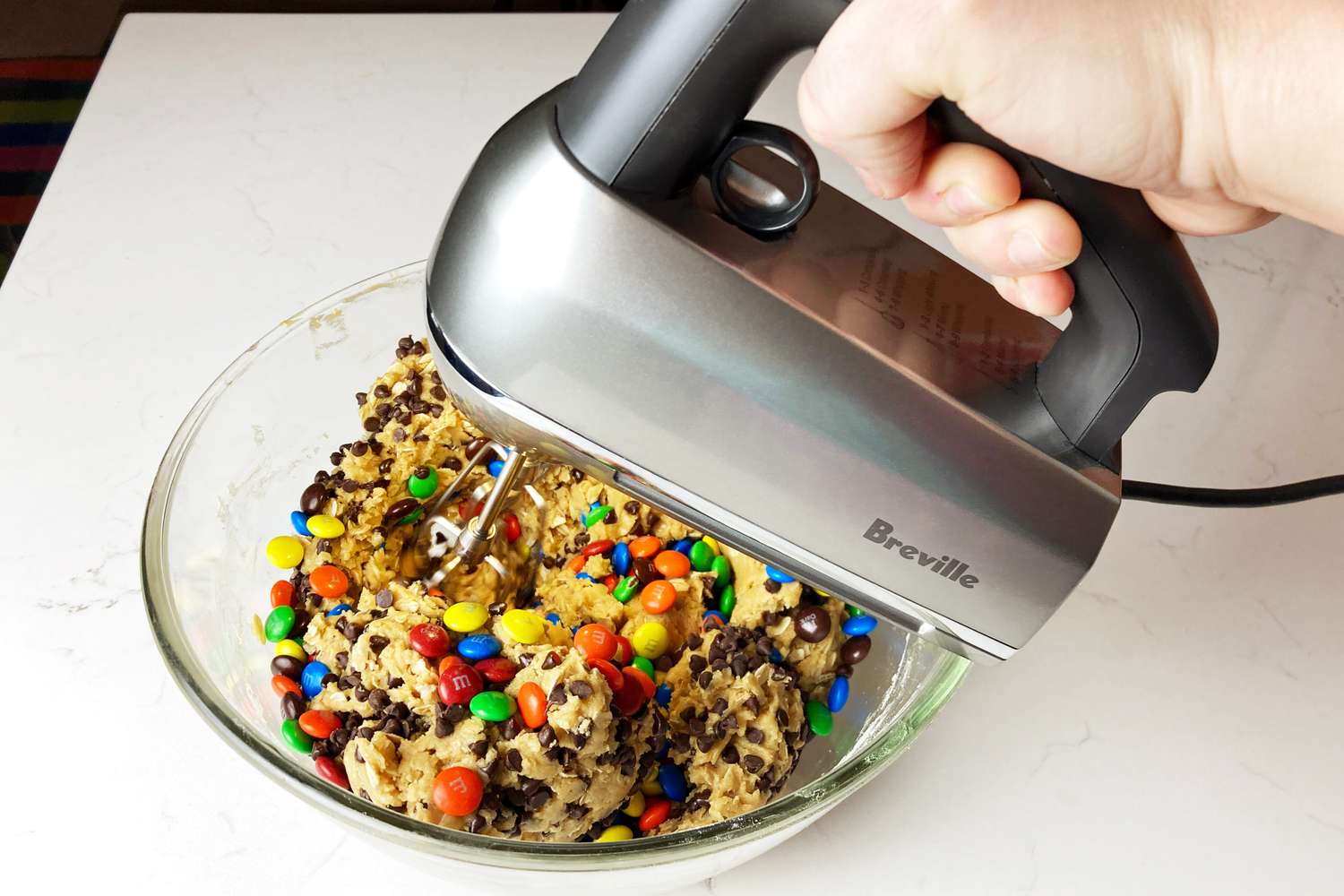 Hand mixing candy filled dough with the Breville The Handy Mix Scraper