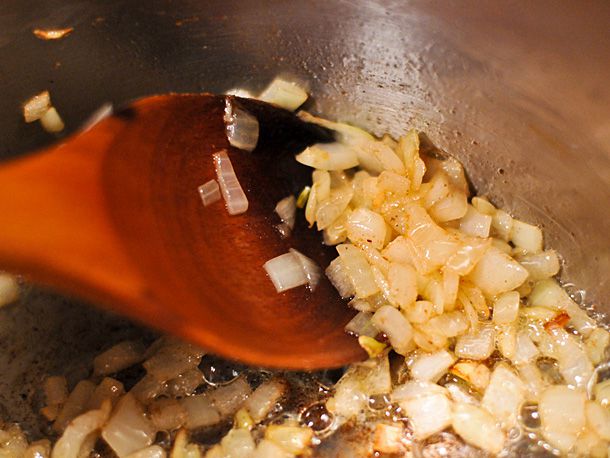 Closeup of onions cooking in butter.