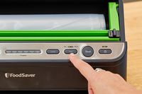 A close-up of the a button on the FoodSaver V4400 2-in-1 Vacuum Sealer Machine