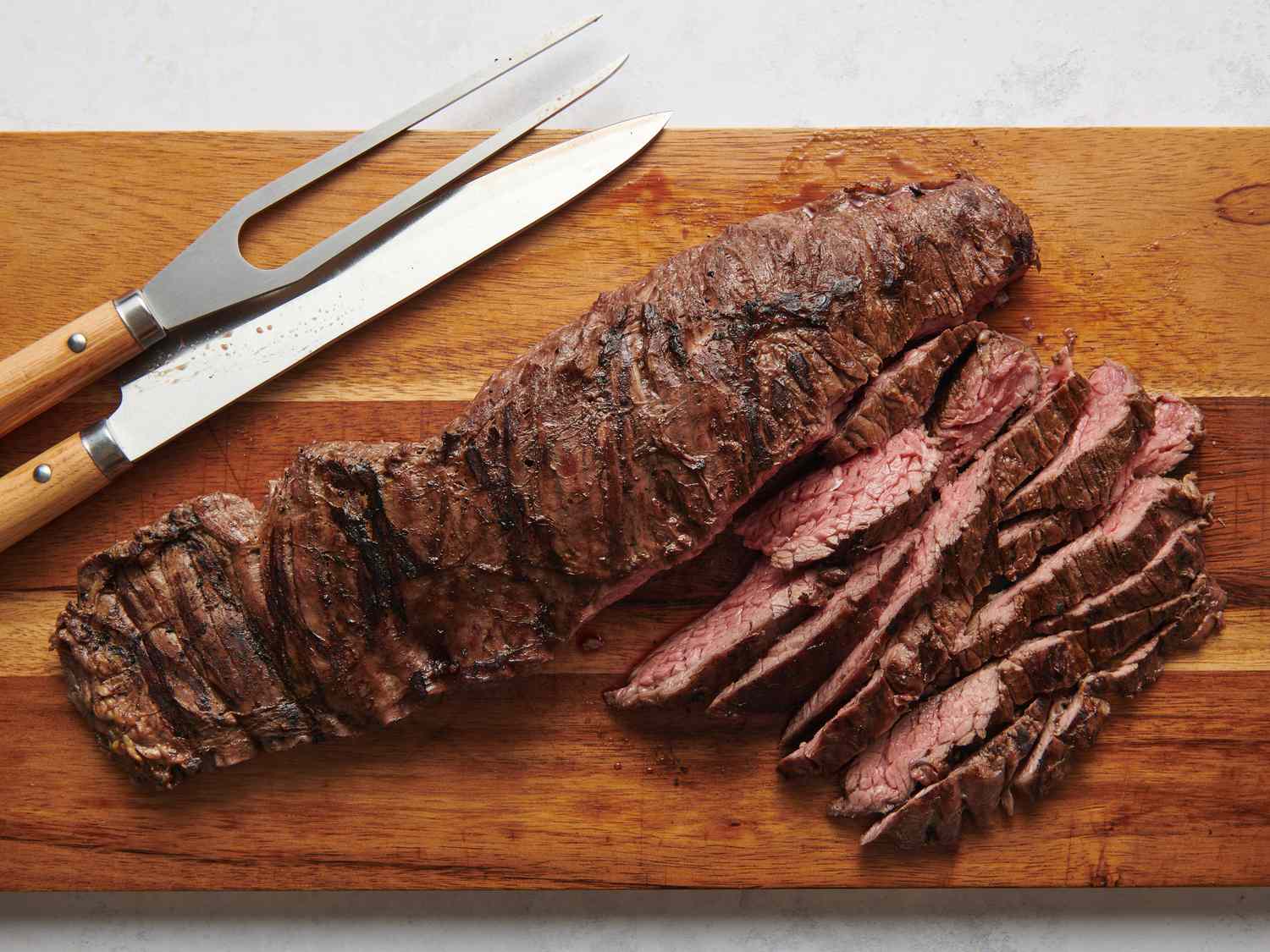 Steak sliced against the grain on cutting board